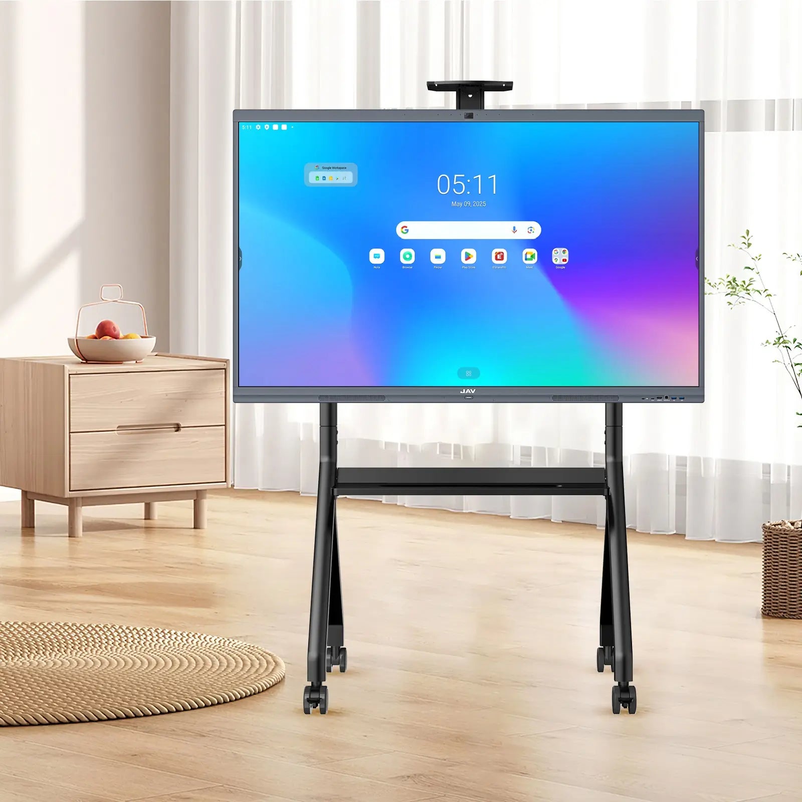 JAV H10 Pro interactive flat panel display on a mobile rolling stand showing its home screen interface within a modern bedroom setting.