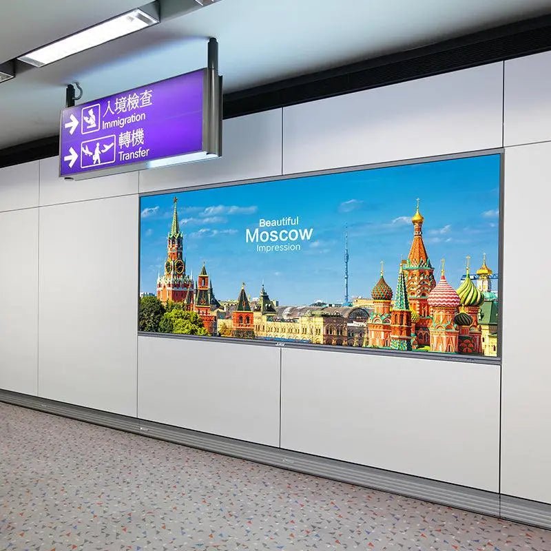 JAV H15 Interactive Flat Panel (or similar JAV large screen) used as digital signage in a public transit area, displaying a 'Beautiful Moscow' image below an airport sign.