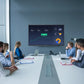 Business professionals analyzing KPI dashboard and charts presented on a large JAV interactive display in a meeting room.