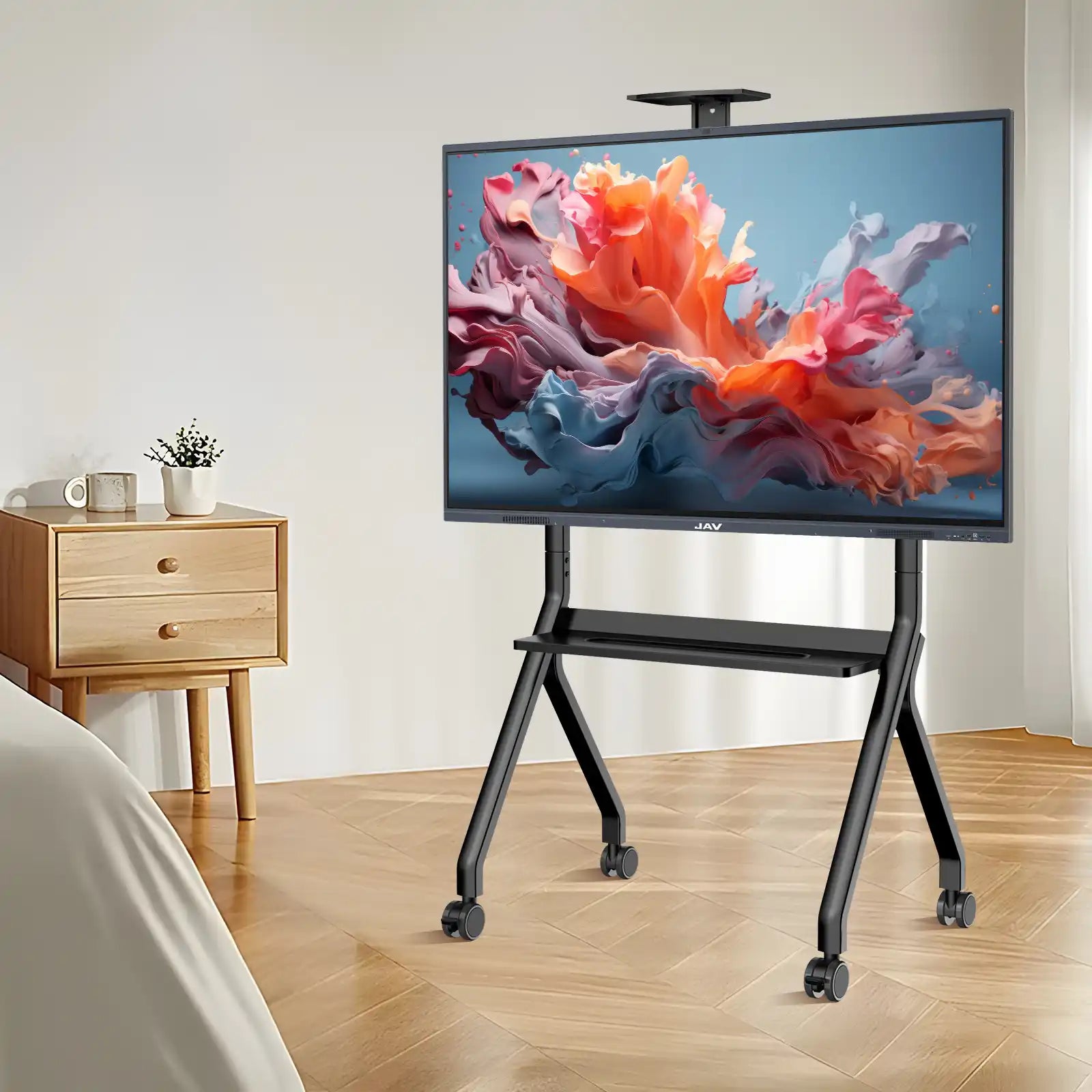JAV smart board displaying colorful abstract art while positioned on a black mobile rolling stand in a modern room.