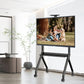 JAV smart board on a black mobile rolling stand displaying a family photo within a contemporary living room setting.