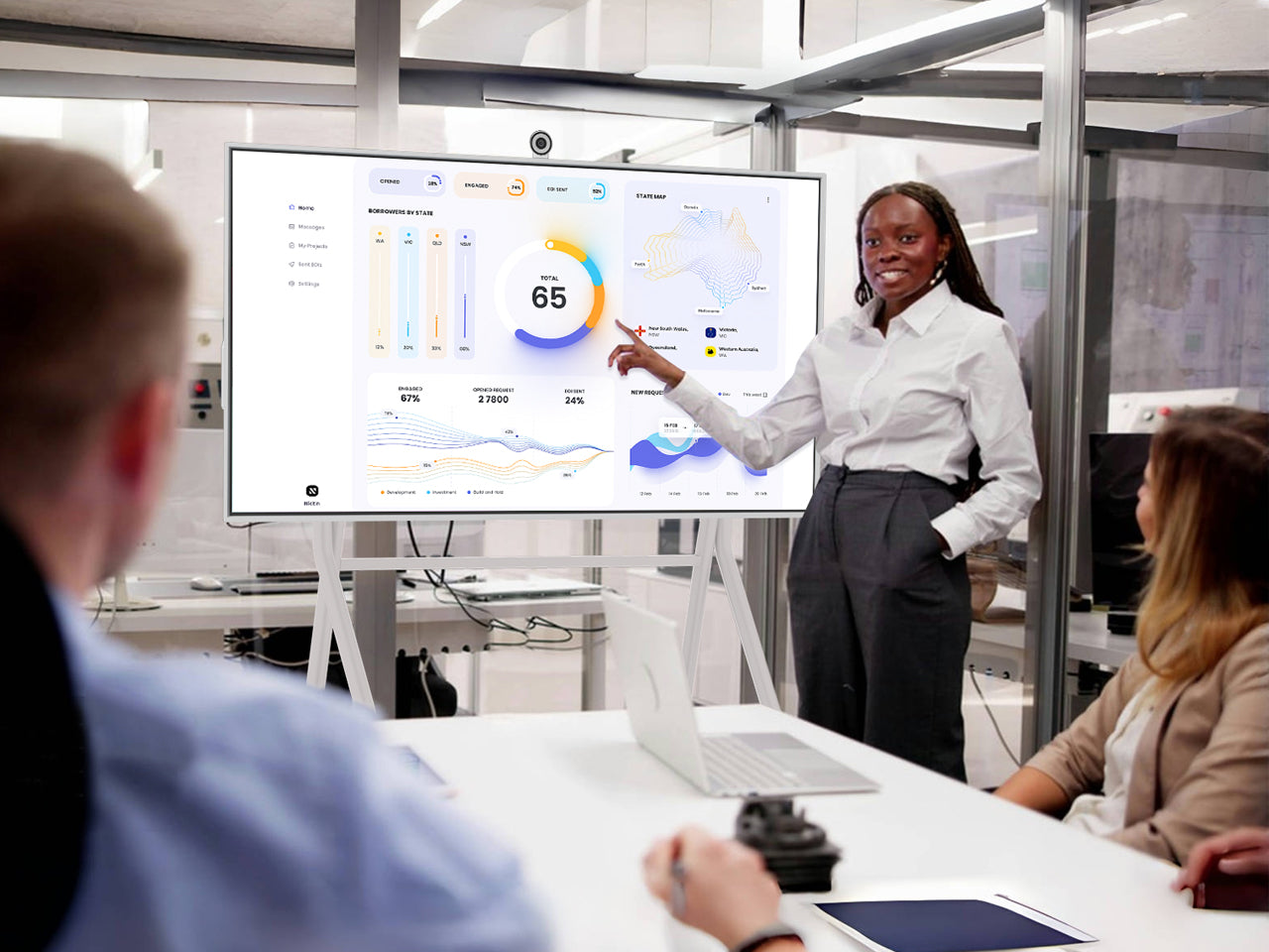 JAV H13S smart board on a white rolling stand being used for a business presentation featuring data visualizations and KPIs in an office setting.
